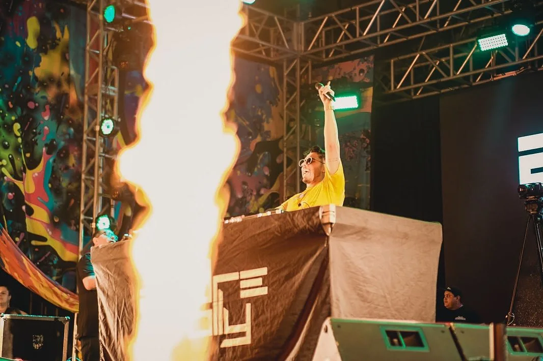 DJ no palco com estrutura de som e luz